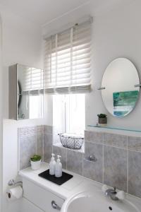 a bathroom with a sink and a mirror at Wonderful Seafront Home - Panoramic Ocean Views in Selsey