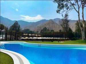 a large swimming pool with mountains in the background at HOTEL RUSTICA CIENEGUILLA in Cieneguilla