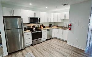 a kitchen with white cabinets and a stainless steel refrigerator at The Lofts on Clematis 202 Downtown West Palm Beach in West Palm Beach