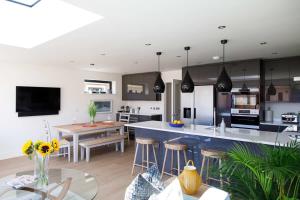 a kitchen with a large island in a room at Luxury designer coastal home for 10 with hot tub in West Wittering