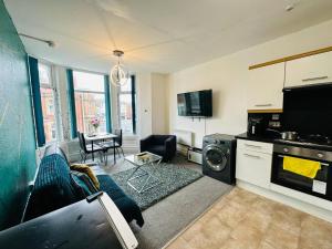 a living room with a couch and a kitchen with a microwave at Luminous Suites in Blackpool