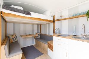 uma cozinha com um beliche e um lavatório em Gorgeous Shepherds Hut - Walk to Beach & Pub em West Wittering