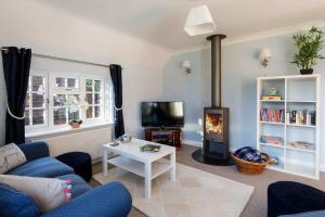 a living room with a couch and a fireplace at Quaint Coastal Cottage - 5 mins from Beach in West Wittering