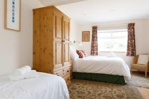 - une chambre avec 2 lits et une armoire en bois dans l'établissement Sunny seafront chalet - sleeps 6, à Chichester