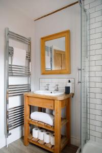 Charming three-bedroom central townhouse في شيشستر: حمام مع حوض ومرآة