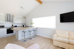 a kitchen and living room with a large window at Countryside Bungalow for 4 Close to Beaches in Birdham