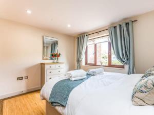 a bedroom with a large white bed and a window at Modern Ground Floor Apartment with Parking in Fishbourne