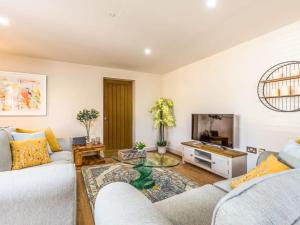 a living room with two couches and a tv at Modern Ground Floor Apartment with Parking in Fishbourne