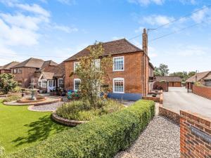 a brick house with a garden in front of it at Modern Ground Floor Apartment with Parking in Fishbourne