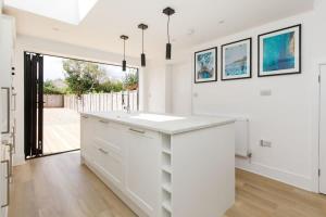 a white kitchen with a sink and a large window at Stylish 2 Bed City Stay in Chichester +32 photos