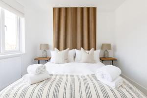 1 dormitorio blanco con 1 cama grande con almohadas blancas en Stylish 2 Bed City Stay, en Chichester
