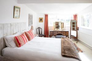 a bedroom with a large white bed and a desk at Pretty Cottage Near City & Sea in Fishbourne