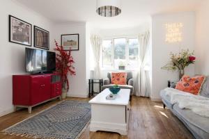 a living room with a couch and a tv at Beachside Retreat for 8 Close to Village in East Wittering