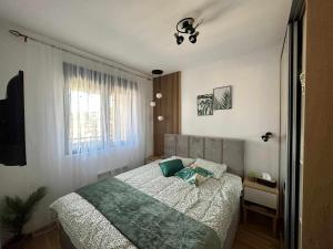 une chambre avec un lit et une fenêtre dans l'établissement Apartman MOMENTUM, à Zlatibor