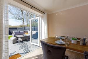 Modern & Stylish Seaside Escape في Earnley: غرفة طعام مع طاولة وباب زجاجي منزلق