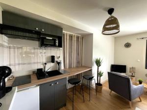 a kitchen with a counter and stools in a room at Appartement T2, 27 m2, rénové in Carquefou