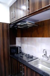 a kitchen with a stove and a sink at Bahria Prime Apartments in Lahore