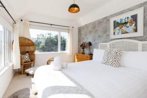 a bedroom with a white bed and a window at Beachside Retreat for 8 Close to Village in East Wittering