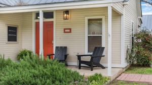 a house with a bench and a red door at Angel's Diamond in town private cottage hot tub in Fredericksburg