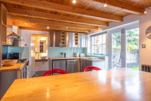 una cucina con un grande tavolo in legno e sedie rosse di Stylist Split Level 2 Bed with Parking a Hambrook