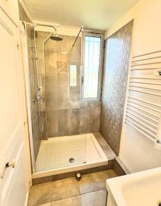 La salle de bains est pourvue d'une douche avec une porte en verre. dans l'établissement Lou Castèu, à Cassis