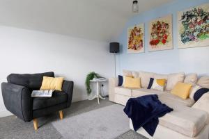 sala de estar con sofá y silla en Two-bed beachside apartment West Wittering, en West Wittering