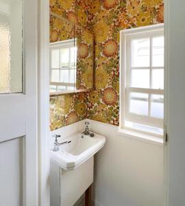 a bathroom with a sink and a mirror at Charming Town House With Garden & Sea View in Bognor Regis