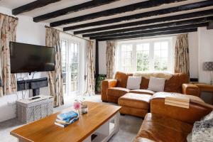 a living room with a couch and a tv at Tranquil Luxe in Country Cottage in Bosham