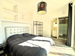 ein Schlafzimmer mit einem großen Bett und einem Kronleuchter in der Unterkunft Lou Castèu in Cassis