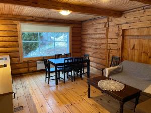 a dining room with a table and chairs in a log cabin at Tiku Holiday Homes in Kiidjärve