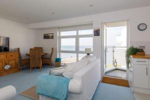 a living room with a white couch and a large window at Two Bed Seafront Escape in East Wittering in East Wittering