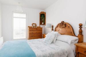 a bedroom with a large bed with a wooden headboard at Two Bed Seafront Escape in East Wittering in East Wittering