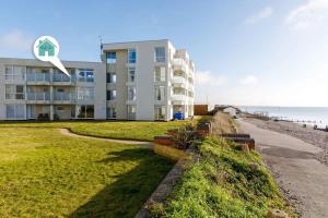 a building on the beach next to the ocean at Two Bed Seafront Escape in East Wittering in East Wittering