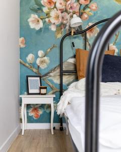 a bedroom with a painting of flowers on the wall at Flamenco Apartament Gdańsk in Gdańsk