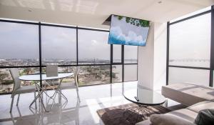 a living room with a table and chairs and large windows at Suite 1202 Bellini, Puerto Santa Ana, Guayaquil in Guayaquil