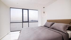 um quarto com uma cama e uma grande janela em Suite 1202 Bellini, Puerto Santa Ana, Guayaquil em Guayaquil