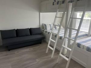 een slaapkamer met een stapelbed en een bank bij Waterfront house on Sam Rayburn - Sleeps 23! in Brookeland