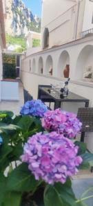 Un mazzo di fiori viola davanti a un tavolo di LuSi Capri House a Capri