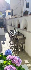 a table and chairs on a balcony with flowers at LuSi Capri House in Capri +34 photos