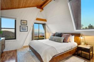 1 dormitorio con 1 cama en una habitación con ventanas en Cedar Mountain Lodge With Hot Tub Views And Wildlife, en Evergreen