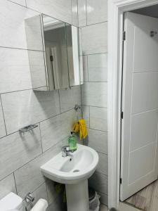 a white bathroom with a sink and a mirror at City Dreams in Croydon