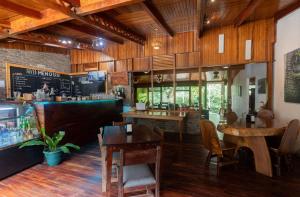 um restaurante com pisos e mesas de madeira e um bar em Elida Lodge Monteverde em Monteverde