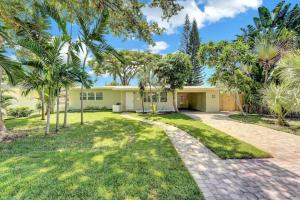 a home with palm trees and a driveway at Beachtown Getaway with Tiki Hut in Pompano Beach