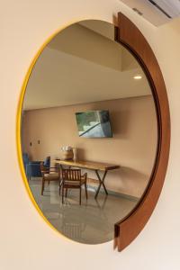 um espelho circular na parede de um quarto com uma mesa e cadeiras em Hotel Wellness - Belleza y Serenidad em Boca del Río
