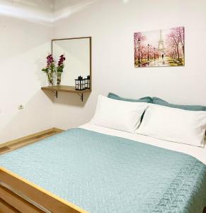 a bedroom with a bed with a blue comforter at Nesi apartmenti in Pristina