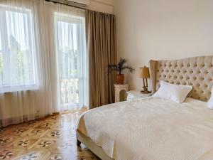 a bedroom with a large bed and large windows at Veranda Boutique Hotel Kutaisi in Kutaisi