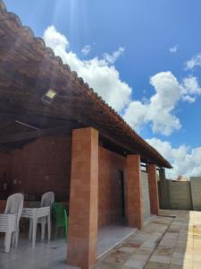 a patio with white chairs and a table at Casa em Gravatá in Gravatá