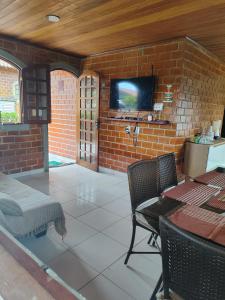 a room with a brick wall with a tv on a wall at Casa em Gravatá in Gravatá