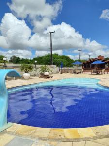 uma piscina com água azul num resort em Casa em Gravatá em Gravatá