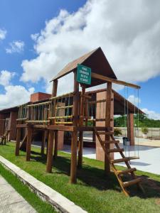 a large wooden building with a playground in front of a building at Casa em Gravatá in Gravatá